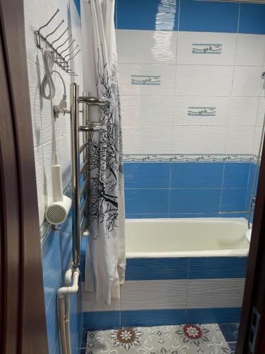 a bathroom with blue and white tiles and a tub at Three rooms Apartment with all facilities in Tashkent