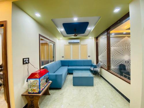 een woonkamer met een blauwe bank en een aquarium bij Hotel Agra YS Taj Hotel in Agra