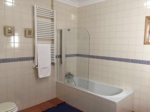 a bathroom with a tub and a toilet at Quinta do Pinheiral in Favões