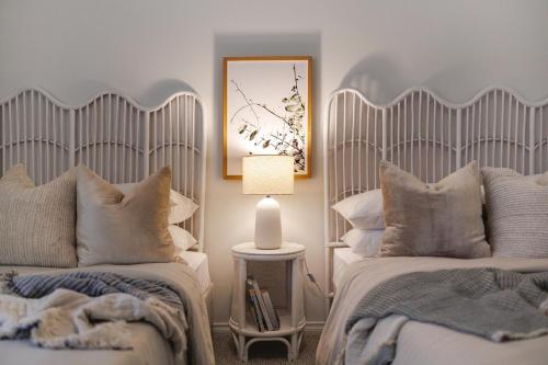 ein Schlafzimmer mit 2 Betten und einer Lampe auf einem Tisch in der Unterkunft Newly Renovated Cottage sleeps 6 in Lake Albert