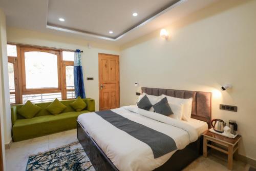 a bedroom with a bed and a green couch at Mystic Hills Retreat in Shimla