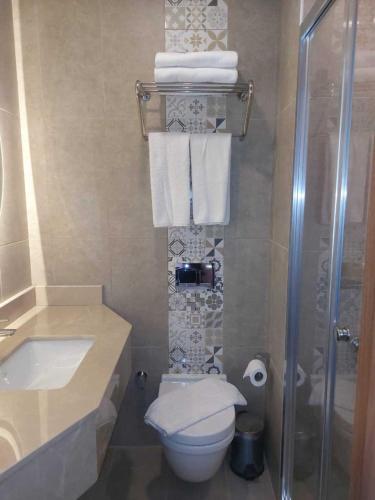 a bathroom with a toilet and a shower and towels at Four Sides Beyoglu in Istanbul
