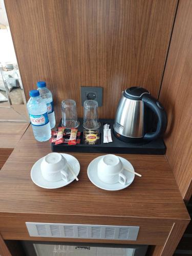a counter with two plates and a tea pot and water at Four Sides Beyoglu in Istanbul