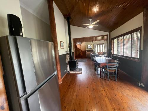 Il comprend une cuisine et une salle à manger avec un réfrigérateur et une table. dans l'établissement Shinglers Cottage, à Mayers Flat