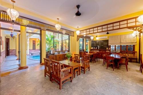 a restaurant with tables and chairs and a pool at Thanh Van 1 Hotel in Hoi An