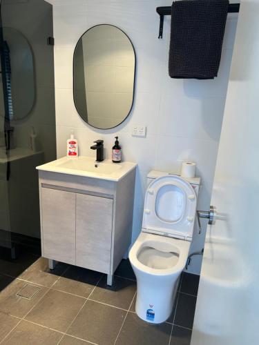un bagno con un water, un lavandino e uno specchio di Waters Edge Luxury Lakeside Studio a Rocky Point