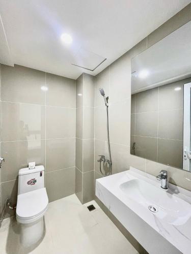 a bathroom with a toilet and a sink and a mirror at Sea House Nha Trang in Nha Trang