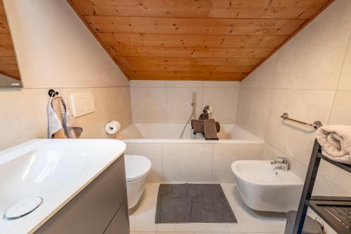 a bathroom with a tub and a toilet and a sink at Haus Oberzöhr in Nova Ponente