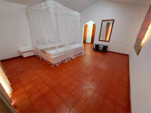 an empty room with a bed and a mirror at Helios Beach Resort in Tangalle