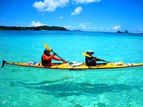 two people in a yellow kayak in the water at Cha Villa in Zamami