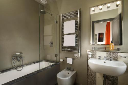 a bathroom with a sink and a shower and a tub at Hotel Universo - WTB Hotels in Florence