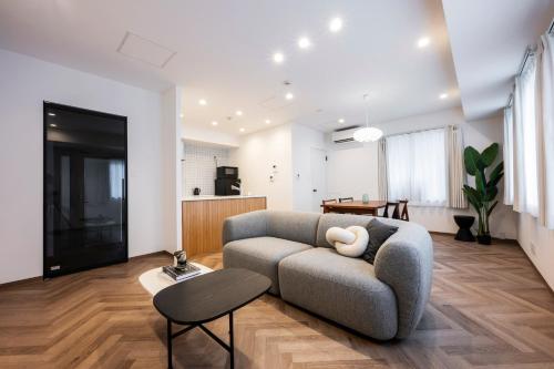 a living room with a couch and a table at GIVE Meidaimae in Tokyo