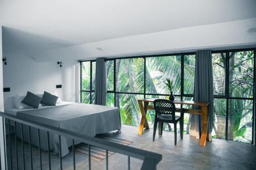 a bedroom with a bed and a table with a chair at VODA Hotel in Galle