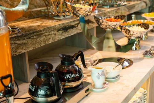 a counter with two coffee pots and cups on it at Ruby Hotel in Nha Trang