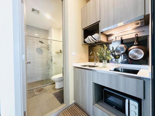 a small kitchen with a sink and a toilet at Modern condo nr BTS ONNUT WIFI with workroom in Bangkok