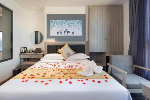 a bedroom with a bed with red flowers on it at Ruby Hotel in Nha Trang