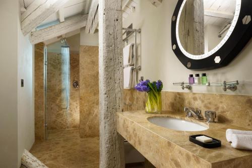 bagno con lavandino e specchio di Hotel L'Orologio - WTB Hotels a Venezia