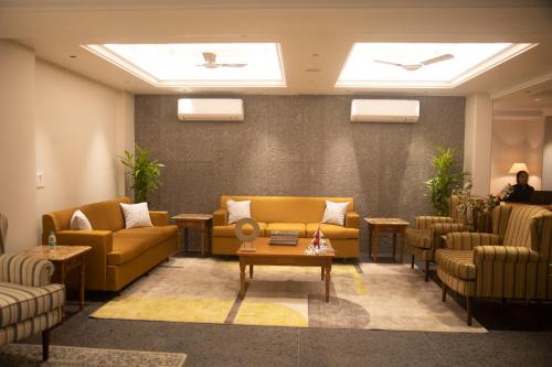 a waiting room with couches and chairs and a table at Eden Wellness and Hospitality in Dehradun