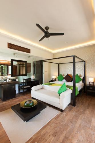 a bedroom with a bed and a living room at Le Relax Luxury Lodge in La Digue