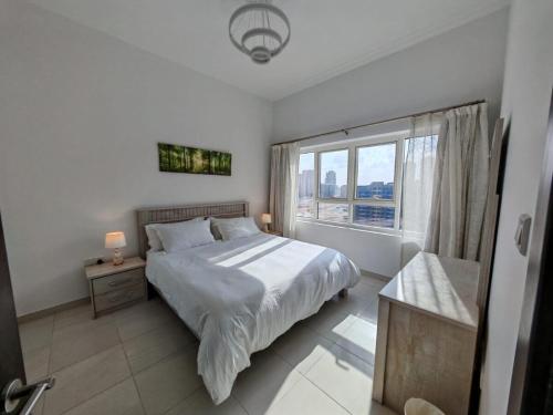 a bedroom with a bed and a large window at Silicon Heights II in Dubai
