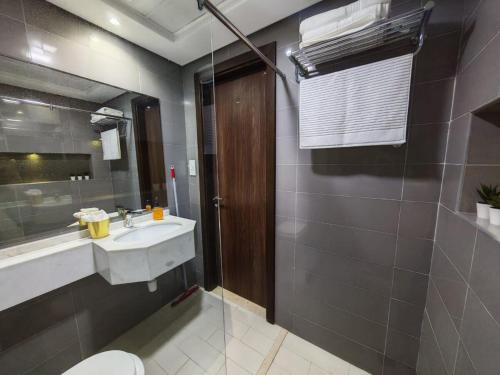 a bathroom with a sink and a toilet and a mirror at Silicon Heights II in Dubai