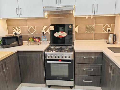 a kitchen with a stove and a microwave at Silicon Heights II in Dubai