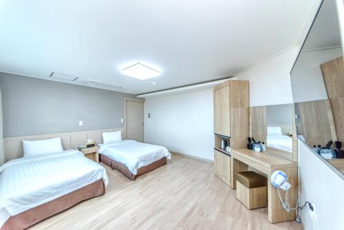 Postel nebo postele na pokoji v ubytování Jungmoon City Hotel & J-hill Hotel