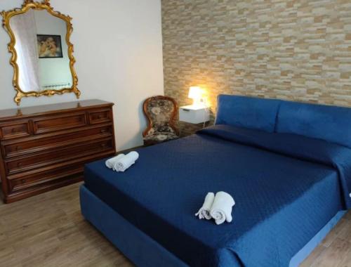 Un dormitorio con una cama azul y un espejo. en Bombana Beach - Vicino, en Fontane Bianche