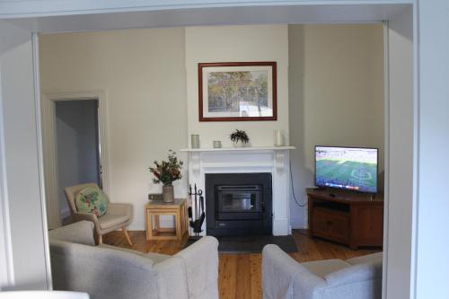 a living room with a television and a fireplace at Merala a cosy cottage with easy stroll to CBD in Mudgee