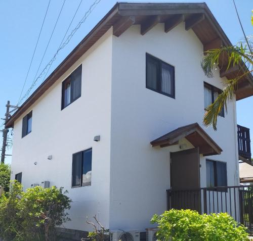 a white building with black windows at Pension Hibiscus - Vacation STAY 14929v in Sesoko