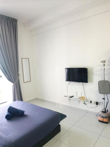 a bedroom with a bed and a flat screen tv at Skytrees Serviced Apartment Aeon Bukit Indah with TV box-B22 in Johor Bahru