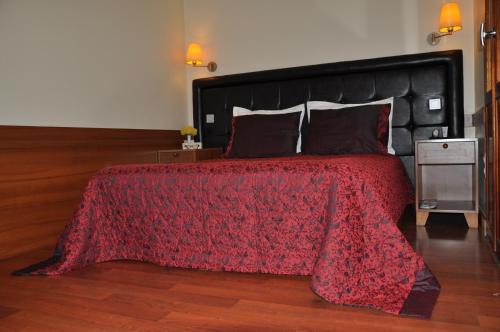 a bedroom with a bed with a red comforter at Butik Pendik Hotel in Istanbul
