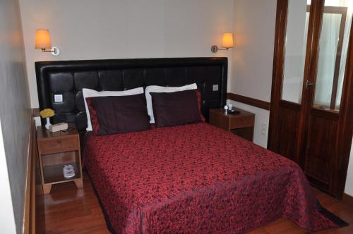 a bedroom with a bed with a red comforter and pillows at Butik Pendik Hotel in Istanbul