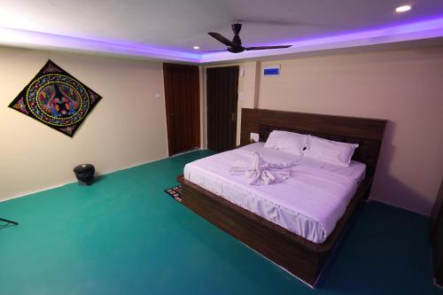 a bedroom with a large bed with a purple light at Shriman Valley in Konārka