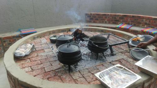 a group of pots and pans on a brick oven at Hotel Portao Diaz in Mossel Bay