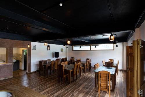 a dining room with wooden tables and chairs at Green Garden Wayanad Villas in Vayittiri
