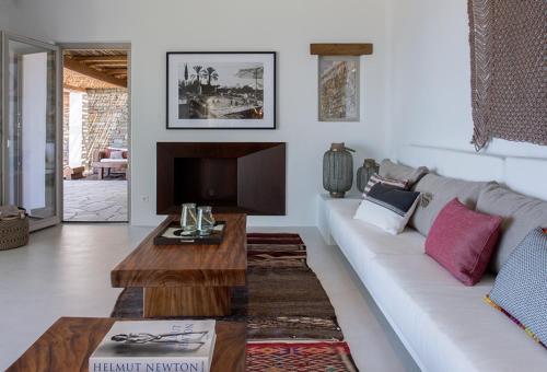 a living room with a white couch and a table at Villa Meltemi in Kardiani