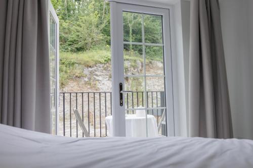 a bedroom with a bed and a large window at Rock Mill Retreat in Stoney Middleton