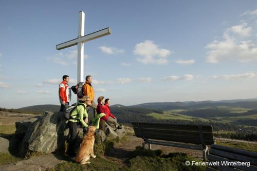 a group of people sitting on a rock next to a cross at Gasthof Holländer Eck in Lennestadt