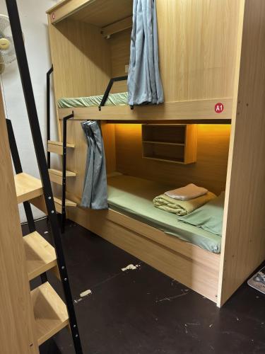 a set of bunk beds with a ladder in a room at Truman Hostel in Luang Prabang
