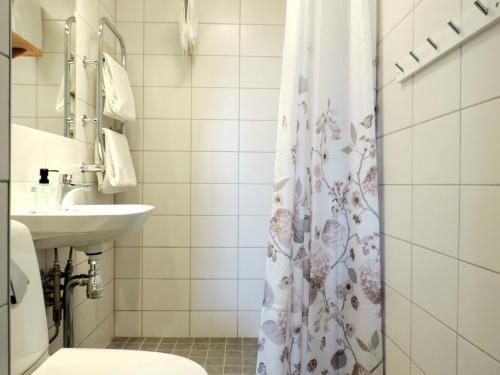 a bathroom with a shower curtain and a sink at Hotell Park in Västervik