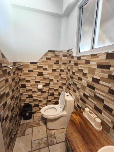 a bathroom with a toilet in a room at Sulu Sunset Beach Resort in Nauhang