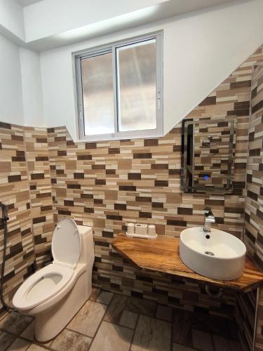 a bathroom with a toilet and a sink at Sulu Sunset Beach Resort in Nauhang