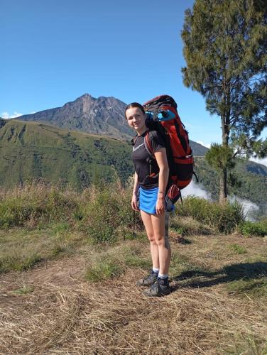 a woman standing on a hill with a backpack at Mimi homestay-LOMBOK in Tetebatu