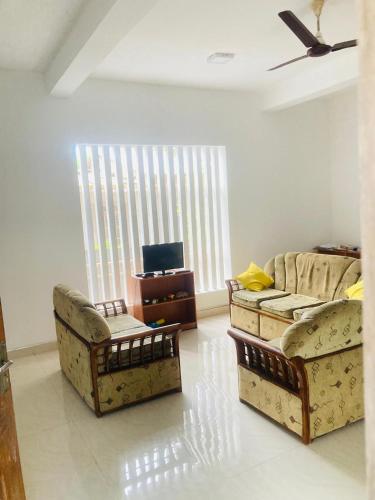 a living room with two couches and a tv at Vintage Rest Anuradhapura in Anuradhapura