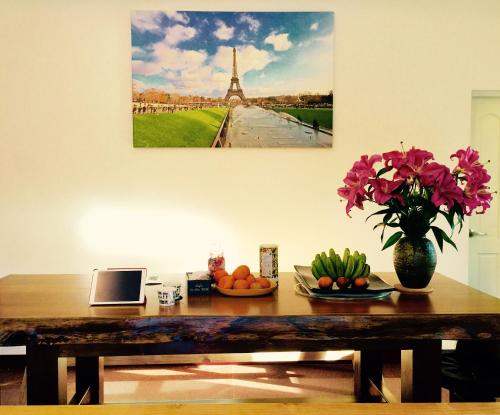 a wooden table with a vase of flowers on it at Love B&B in Sanyi