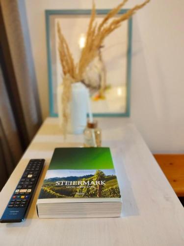 a book sitting on a table next to a remote control at Goldene Pastete - Urban Luxury Apartments City Center in Graz
