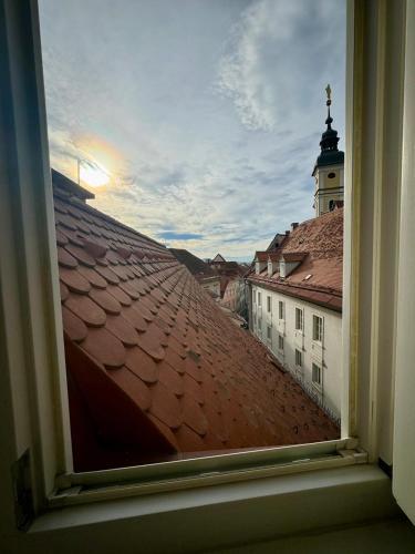 a view from a window of a roof with a tower at Goldene Pastete - Urban Luxury Apartments City Center in Graz