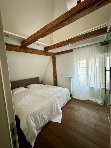 a bedroom with a white bed and a window at Goldene Pastete - Urban Luxury Apartments City Center in Graz