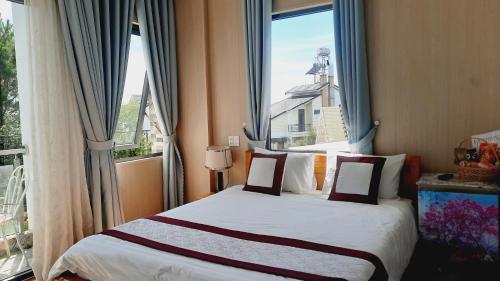 a bedroom with a bed with a large window at NEST House in Ấp Kim Thạch